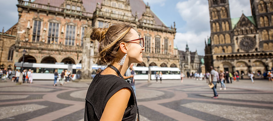 Turista joven disfrutando de una gran vista sobre el edificio del ayuntamiento y la iglesia en el centro de Bremen, Hamburgo